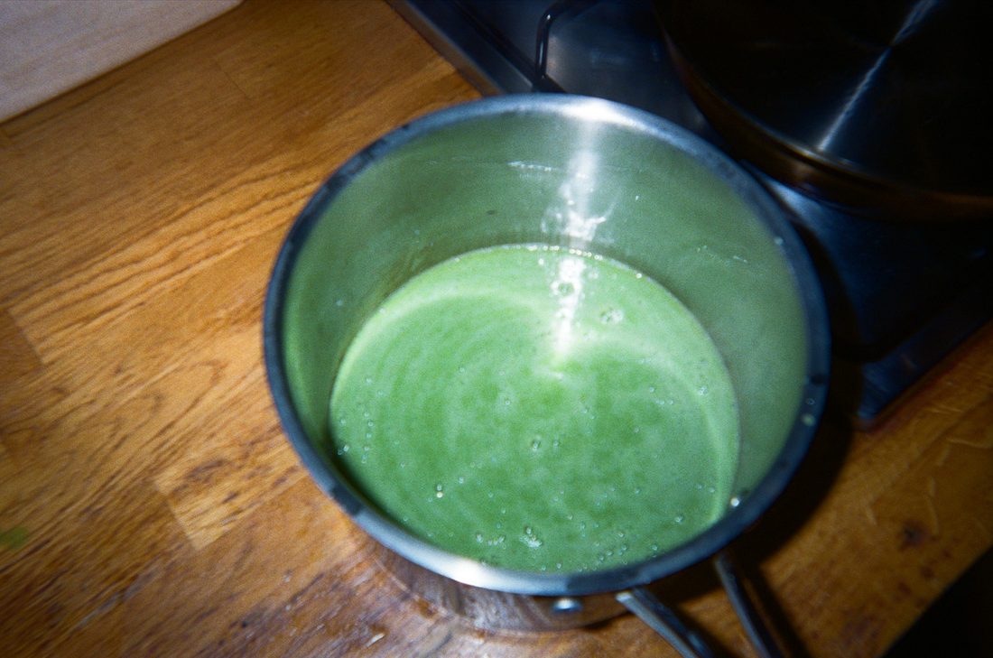 Green sauce in a saucepan on a wooden counter